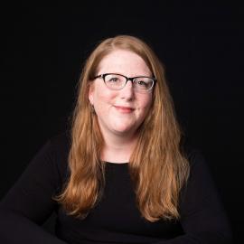 female staff member in front of black backdrop